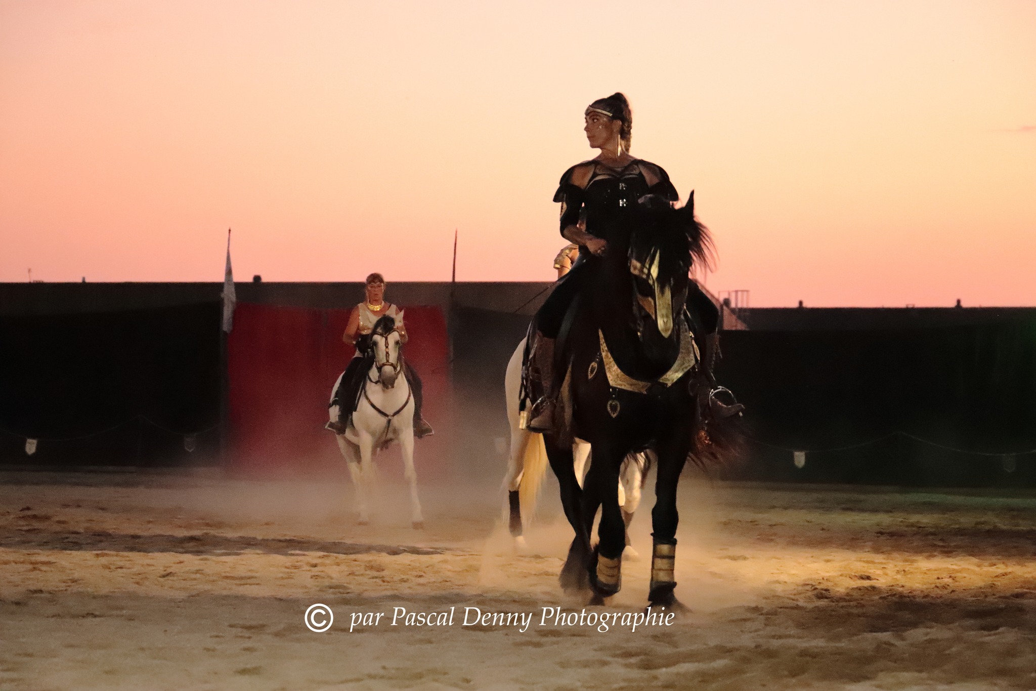 Troupe riders in the arena at dusk
